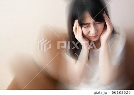 Young female suffering from dizziness, vertigo, headache while sitting on couch at home. Cause of dizzy inclued migraine, stress, stroke, Meniere disease or brain tumor. Health care problem. Young female suffering from dizziness, vertigo, headache while sitting on couch at home. Cause of dizzy inclued migraine, stress, stroke, Meniere disease or brain tumor. Health care problem. 66133629