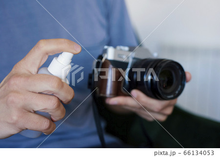 man disinfecting his camera man disinfecting his camera 66134053