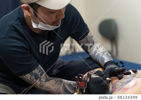 背中に入れ墨する彫り師 刺青 タトゥーの写真素材