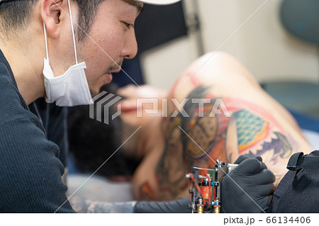 背中に入れ墨する彫り師　刺青　タトゥースタジオ 66134406
