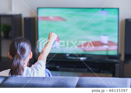 家でスポーツをテレビ観戦する若い女性のイメージ【プロ野球の動画配信サービス】 66135397