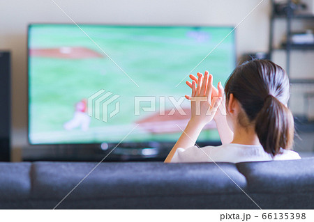 家でスポーツをテレビ観戦する若い女性のイメージ【プロ野球の動画配信サービス】 家でスポーツをテレビ観戦する若い女性のイメージ【プロ野球の動画配信サービス】 66135398
