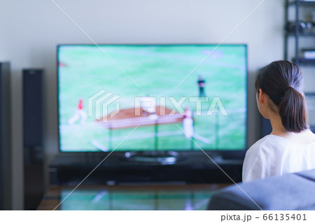 家でスポーツをテレビ観戦する若い女性のイメージ【プロ野球の動画配信サービス】 66135401