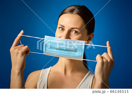 woman in white shirt shows how to wear a mask during a pandemic woman in white shirt shows how to wear a mask during a pandemic 66136315