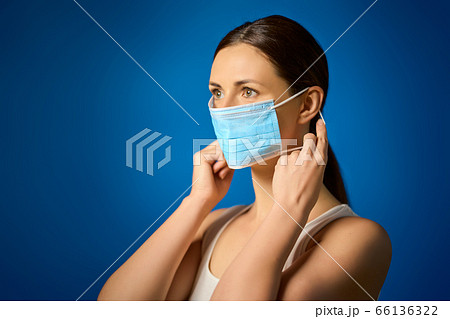 woman in white shirt shows how to wear a mask during a pandemic woman in white shirt shows how to wear a mask during a pandemic 66136322