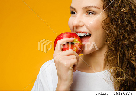 Pretty curly girl with red apple Pretty curly girl with red apple 66136875