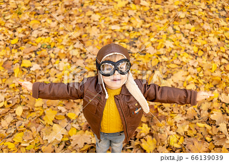 Happy child having fun outdoor in autumn park Happy child having fun outdoor in autumn park 66139039