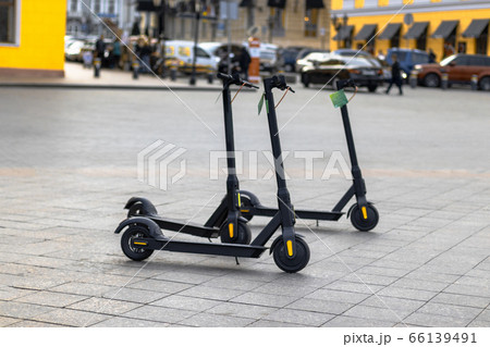 Black electric scooters parked outside for self 66139491