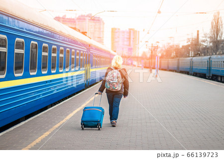 Woman traveler tourist walking with luggage at train station, copy space 66139723