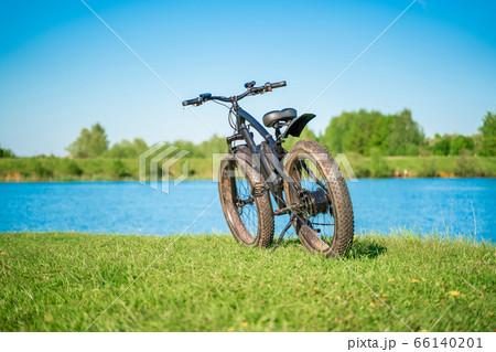 Electric bike with thick wheels near the lake. Electric bike with thick wheels near the lake. 66140201