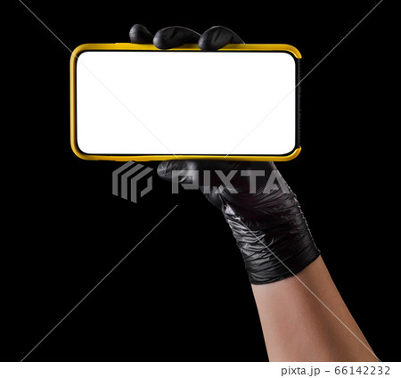 Hand in black glove holding mobile phone with blank screen isolated on black Hand in black glove holding mobile phone with blank screen isolated on black 66142232