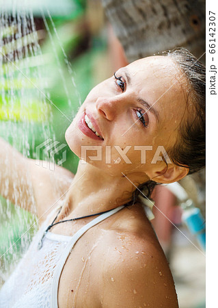 beautiful girl takes a shower on the beach  66142307