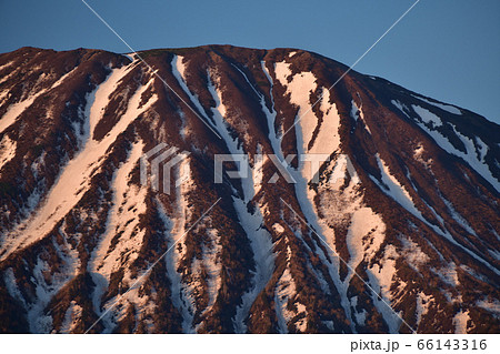 初夏の北海道倶知安町で朝陽に赤く照らされ始めた残雪の羊蹄山の風景 66143316