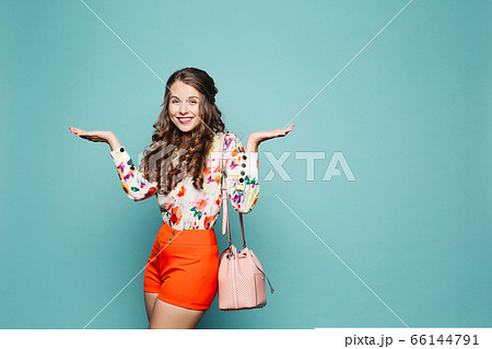 Happy woman with curly hair in elegant clothes 66144791