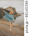 Beautiful girl in a hat on a summer vacation in the mountains on nature. Blue sky and sea. 66145390