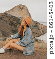 Beautiful girl in a hat on a summer vacation in the mountains on nature. Blue sky and sea. 66145403