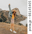 Beautiful girl in a hat on a summer vacation in the mountains on nature. Blue sky and sea. 66145405