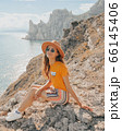 Beautiful girl in a hat on a summer vacation in the mountains on nature. Blue sky and sea. 66145406
