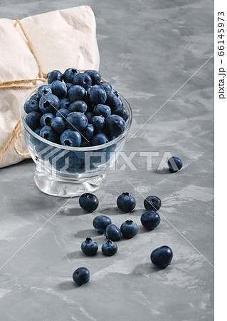 Blueberries on a black background,, fresh berry in a bowl on a concrete background with a wrapped envelope with a berry. copies of space, delivery of berries. Blueberries on a black background,, fresh berry in a bowl on a concrete background with a wrapped envelope with a berry. copies of space, delivery of berries. 66145973