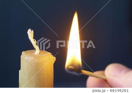 Close-up male hand holds burning match and lights 66146261