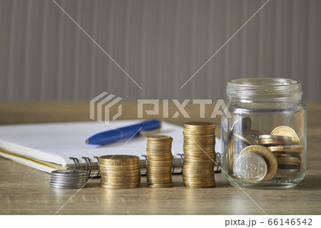Rows of coins and jar coins on wooden table with Rows of coins and jar coins on wooden table with 66146542