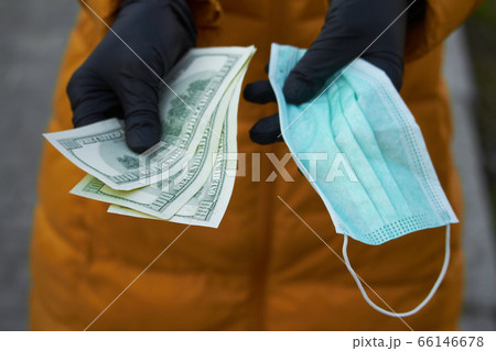 Hands holds 100 dollar bills for a surgical face 66146678