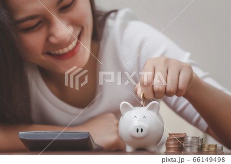Female hand putting money into piggy bank for saving money, save money and management financial concept. Female hand putting money into piggy bank for saving money, save money and management financial concept. 66149498