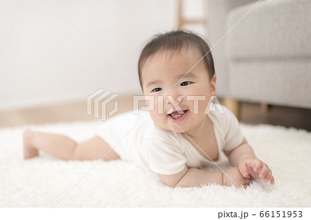 自宅のリビングでハイハイする生後8ヶ月の赤ちゃんの写真素材