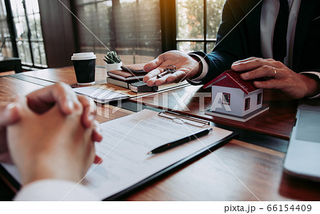 Hand of real estate agent passes the key to new 66154409