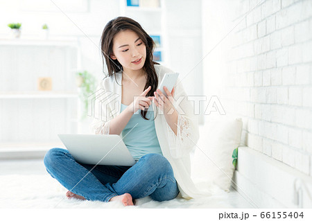 女性がスマホとパソコンを操作している 女性がスマホとパソコンを操作している 66155404