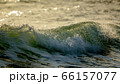 Sea swell wave with spray on top coming to beach 66157077