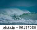 Sea swell wave with spray on top coming to beach 66157080