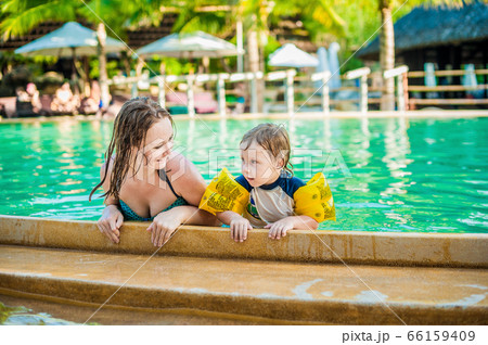 Young cheerful mother and son in a swimming pool Young cheerful mother and son in a swimming pool 66159409