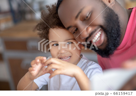 Sweet little girl showing love sign while her father making selfie Sweet little girl showing love sign while her father making selfie 66159417