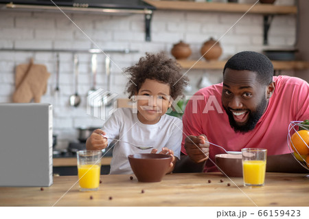 Sweet little girl having breakfast with her dad and feeling great Sweet little girl having breakfast with her dad and feeling great 66159423