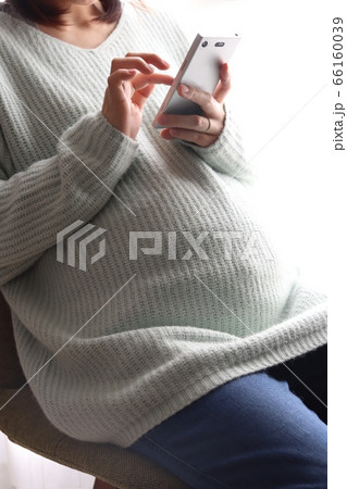 スマホを操作する妊娠8か月の妊婦【白背景】 スマホを操作する妊娠8か月の妊婦【白背景】 66160039