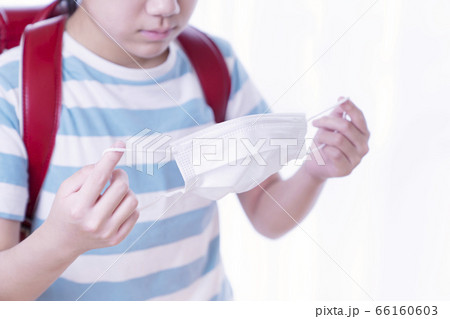 マスクを持つ小学生女の子 66160603