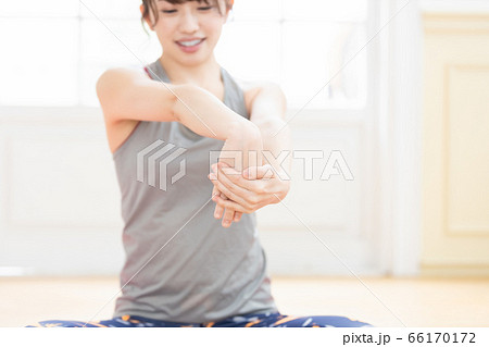 トレーニングウェアを着て腕のストレッチをする女性 トレーニングウェアを着て腕のストレッチをする女性 66170172