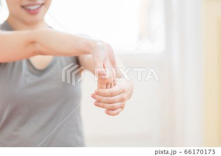 トレーニングウェアを着て腕のストレッチをする女性 66170173