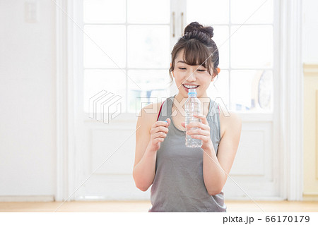 トレーニングウェアを着てミネラルウォーターを持つ女性 トレーニングウェアを着てミネラルウォーターを持つ女性 66170179