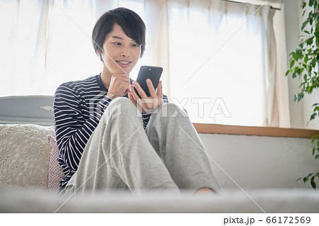 家でスマホを見る若い男性 家でスマホを見る若い男性 66172569
