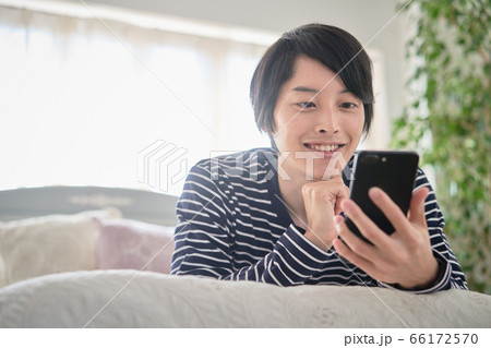 家でスマホを見る若い男性 家でスマホを見る若い男性 66172570