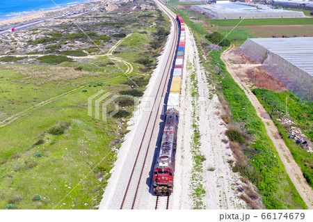 Freight Train hauling a long load of Shipping Containers. 66174679