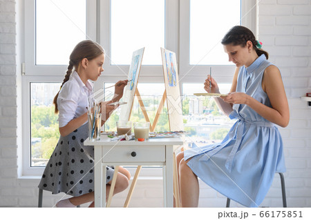 The girl learns to paint at the tutor, together 66175851