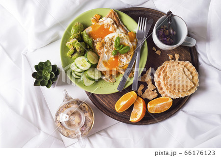 Fried eggs with toasts and tea in bed Fried eggs with toasts and tea in bed 66176123