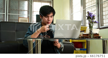Smart man in denim shirt drinking a coffee while working. 66176751