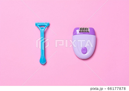 Purple epilator and blue razor on a pink Purple epilator and blue razor on a pink 66177878
