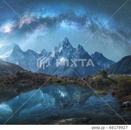 Milky Way over snowy mountains and lake at night. Landscape with snow covered high rocks and stars 66179927