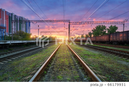 Railway station with blurred high speed train and freight train at colorful sunset. Railroad  66179931