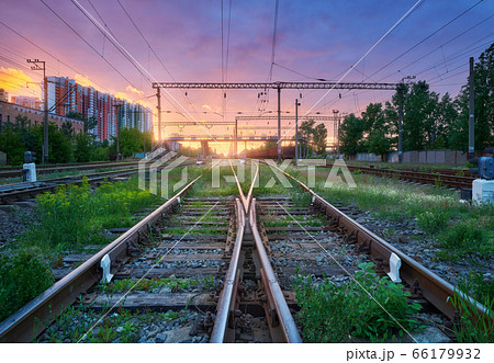Railway station with blurred high speed train and freight train at colorful sunset. Railroad  66179932
